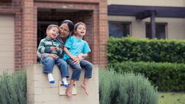 Woman with two kids outside home