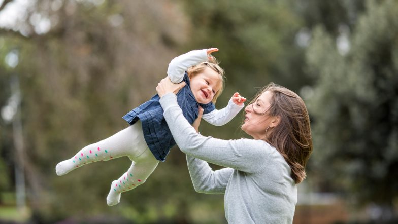 Photograph of a mother in the park with her young daughter.
