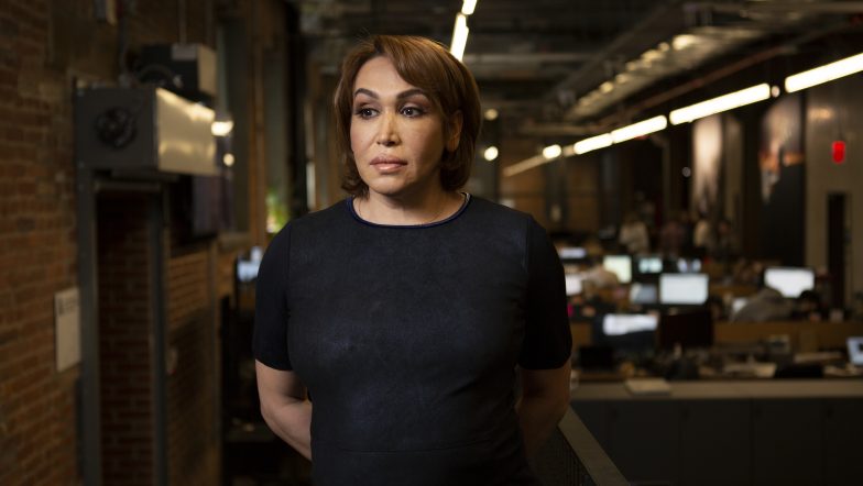 A woman in business attire in an office looking